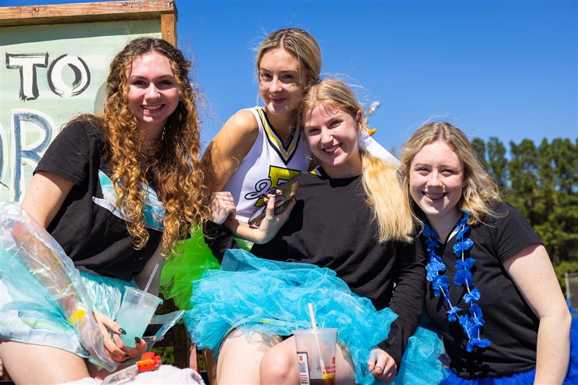 Students ride on a homecoming parade float